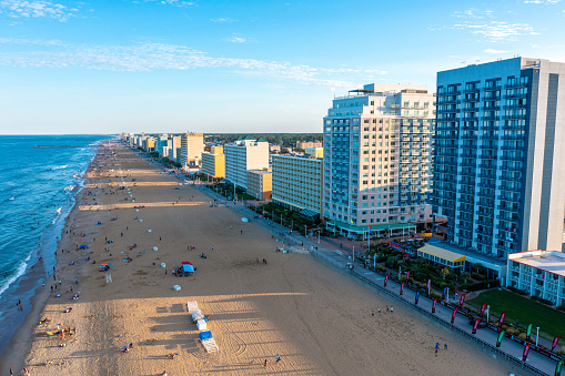 Aerial view of the Virginia Beach oceanfront looking south at sunset. vacationers on the beach and the boardwalk. ocean waves beaking