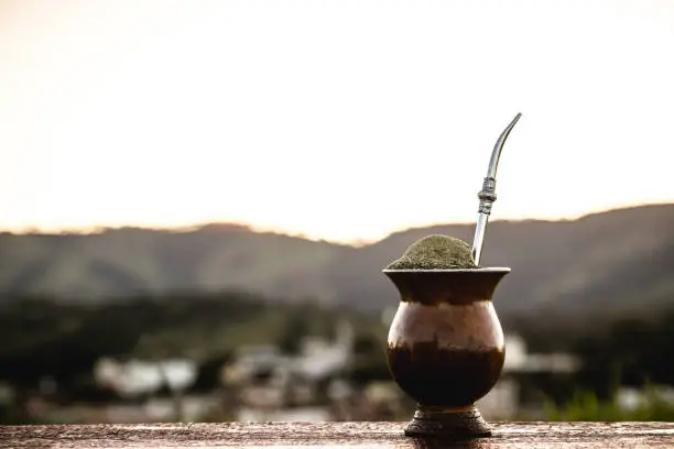 Chimarrão gourd with a small town from Rio Grande do Sul in the background, infusion of yerba mate, served on cold winter days, Symbol drink of Rio Grande do Sul,