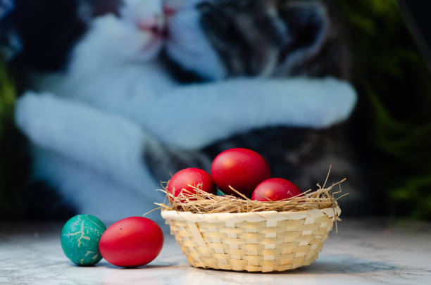 istock Colorful Easter eggs in wicker basket against light background, closeup 1391674682