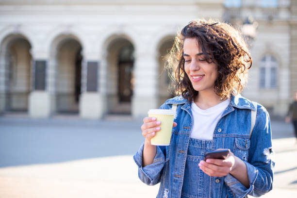 istock Happy young woman using phone 1391675474