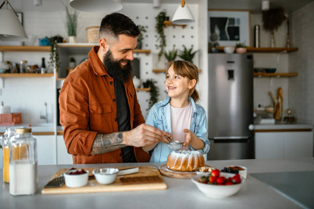 istock Little girl making and decorating cake with her father 1391679610
