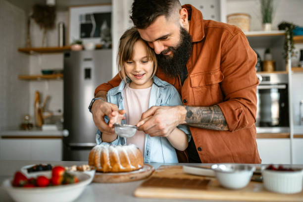 istock Little girl making and decorating cake with her father 1391679626