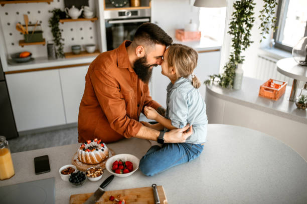 istock Father and daughter cuddling and embracing at home 1391679779
