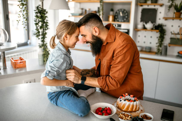 istock Father and daughter cuddling and embracing at home 1391679789