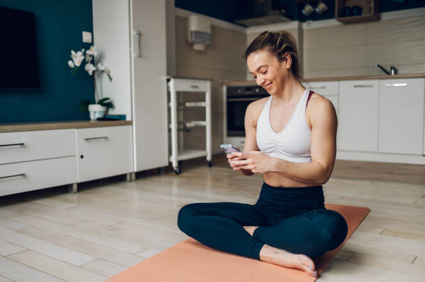 istock Woman using smartphone after training at home 1391682771