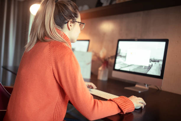 istock A programmer with her back to the camera sits at a desk and works on a computer. 1391685288