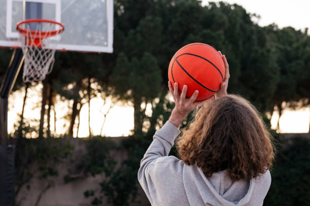istock man throwing a ball into a basketball hoop 1391685396