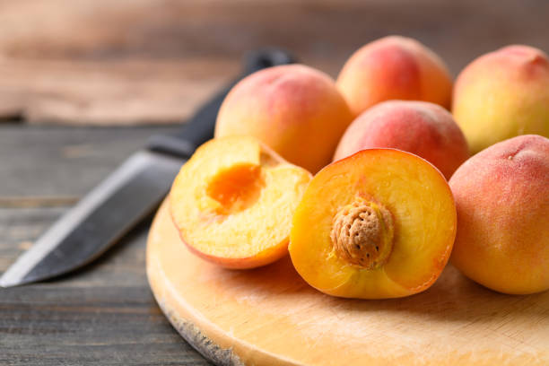 istock Peach fruit on cutting wooden board 1391698754