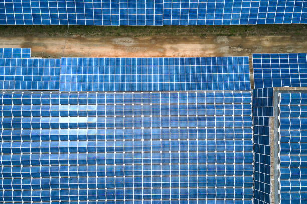 vue aérienne de la centrale solaire avec des panneaux photovoltaïques bleus montés sur le toit du bâtiment industriel pour produire de l’électricité écologique verte. production d’un concept d’énergie durable. - environmental conservation built structure solar power station building exterior photos et images de collection