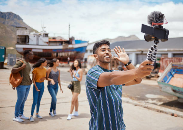 istock Shot of a young man using a digital camera on a tripod while hanging out with his friends outdoors 1391706479