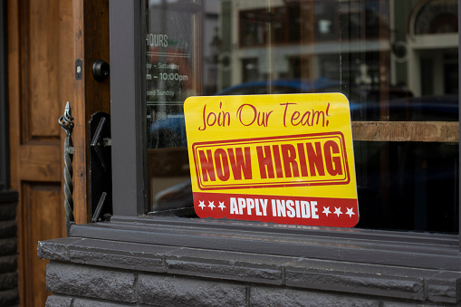 Salem, OR, USA - Mar 31, 2022: Now Hiring sign is seen at the storefront of a local business in Salem, Oregon, as labor shortage persists across the nation.