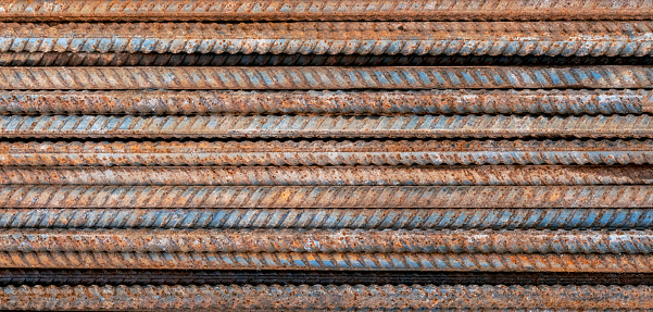 Top view stack of straight old rusty high yield stress deformed reinforcement steel or iron bars.