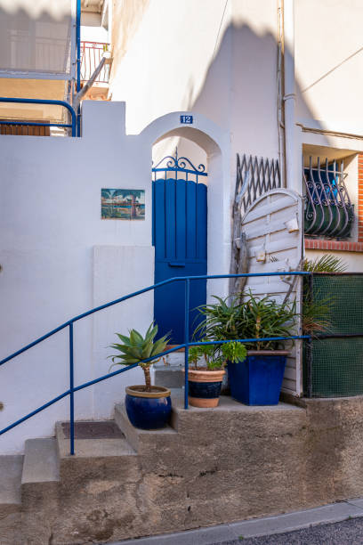 Banyuls-sur-Mer, France - 26 January 2022: Mediterranean style building entrance with whitewashed walls and blue door