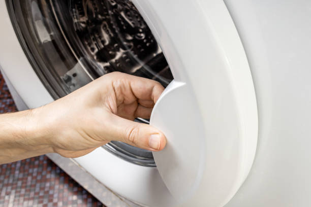 opening washing machine door with metal drum inside. washing appliance service concept. washer repair conceptual stock photo