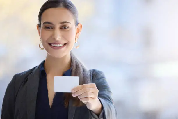 Photo of Portrait of a young businesswoman holding a blank card in an office