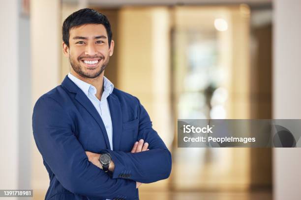 Portrait Of A Confident Young Businessman Standing With His Arms Crossed In An Office Stock Photo - Download Image Now