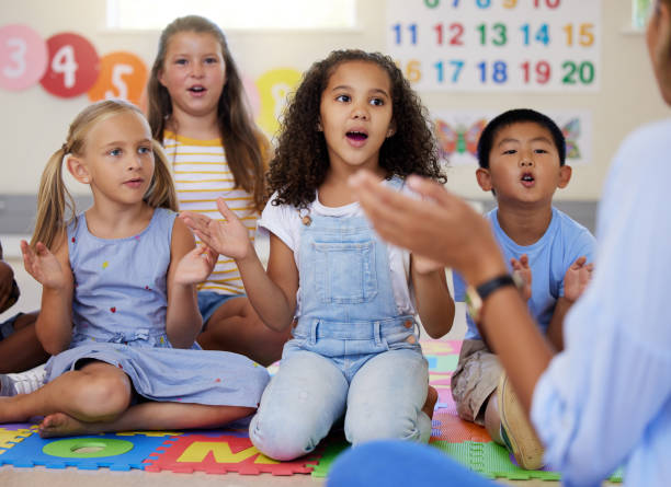 scatto di un gruppo di bambini che cantano in classe - toddler music asian ethnicity child foto e immagini stock