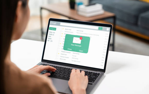 femme utilisant un ordinateur sur la table avec un nouveau message électronique sur un ordinateur portable, un message de connexion de communication à des lettres globales sur le lieu de travail - envoyez photos et images de collection