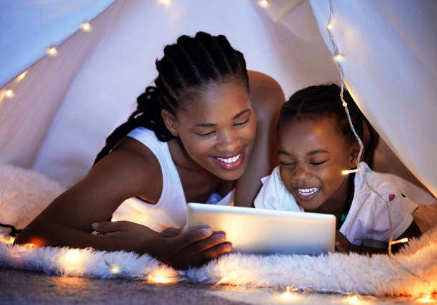 istock Shot of a mother and her daughter using a digital tablet together while relaxing under a blanket fort at home 1391721776