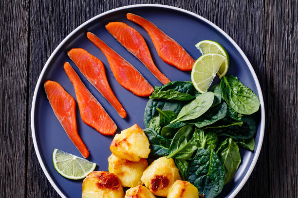 salmon slices with spinach leaves, roast potatoes - smoked salmon salt healthy lifestyle cold imagens e fotografias de stock