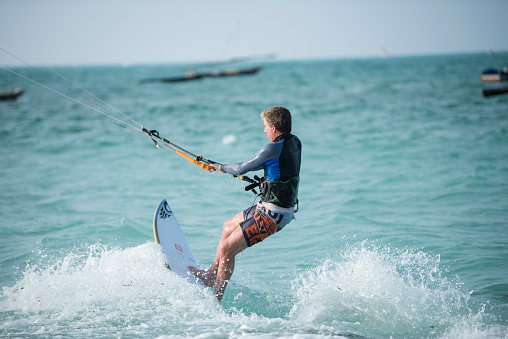 A Skilled Man Joyfully Wakeboarding in the Expansive Sea on a Beautifully Bright Sunny Day,Delighting in the Thrill of Riding the Waves,Splashing Around,and Experiencing the Refreshing Essence of the Seawater Adventure.