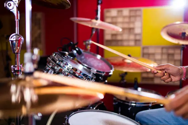 Attractive Teenage Drummer with Drumsticks in recording studio .