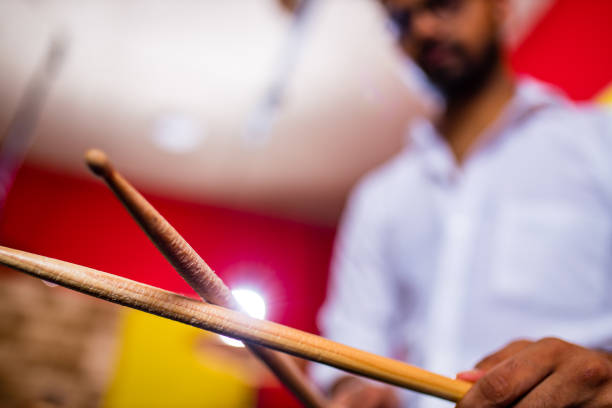 Attractive Teenage Drummer with Drumsticks in recording studio .
