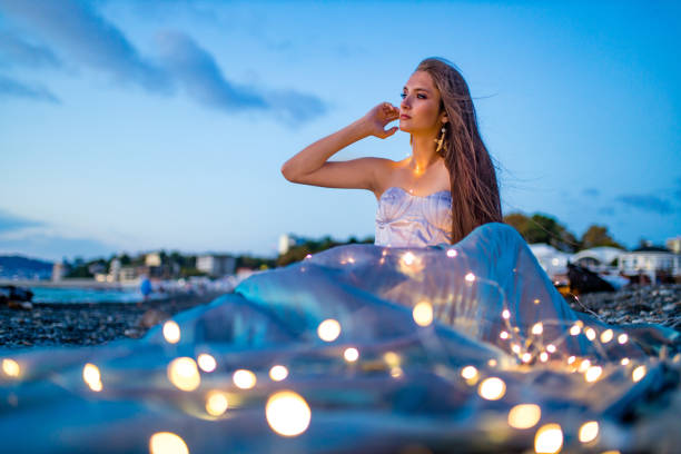 mermaid myth in sunset on beach shore with fish star shells pearls earrings jewelry mermaid myth in sunset on beach shore with fish star shells pearls earrings jewelry. goddess of ocean stock pictures, royalty-free photos & images