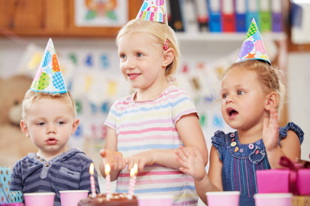 scatto di un bambino in età prescolare che festeggia un compleanno in classe - elementary age focus on foreground indoors studio shot foto e immagini stock