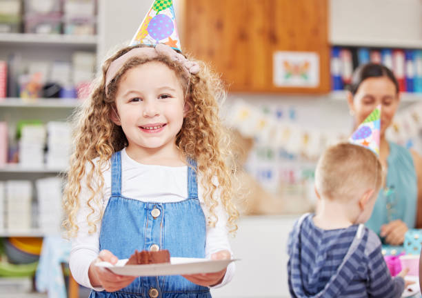 scatto di un bambino in età prescolare che festeggia un compleanno in classe - elementary age focus on foreground indoors studio shot foto e immagini stock