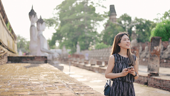 Pov point of view rear view Asian wanderlust women happy travel photographing taking photo with digital device at Wat Phra Si Sanphet, of Ayutthaya, Thailand