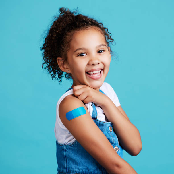 foto de una niña mostrando una curita en su brazo - esparadrapo fotografías e imágenes de stock