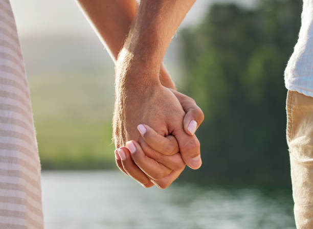 istock Shot of an unrecognizable couple holding hands while spending time at a lake 1391730267