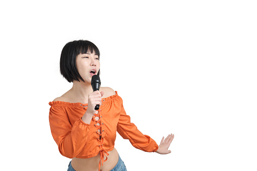 Young asian woman singing and dancing with microphone, isolated on white background.