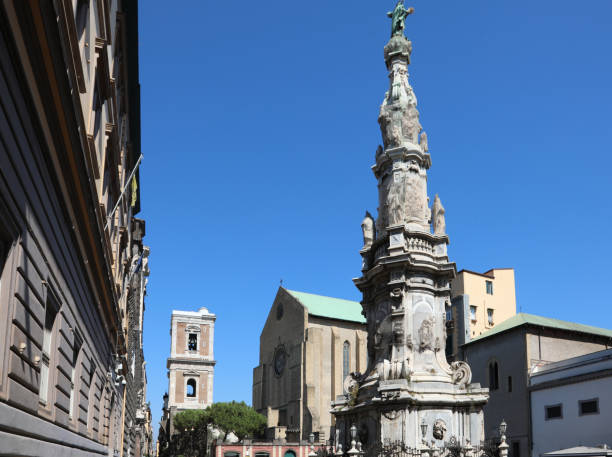 guglia della immacolataと呼ばれる真っ白な尖塔は、イタリアのナポリのバロック様式の装飾が施された高さ34 mの大きな18世紀のオベリスクタイプの記念碑です。 - santa chiara ストックフォトと画像