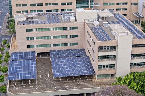 Solar panels on building rooftop and parking area