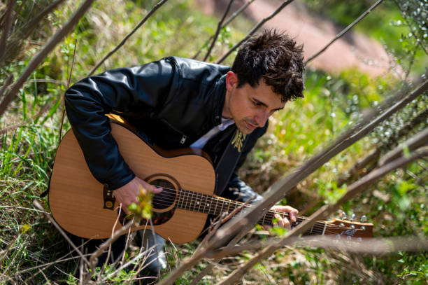 istock boy plays guitar surrounded by nature 1391738831