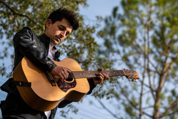 istock boy playing guitar outdoors in nature 1391738856