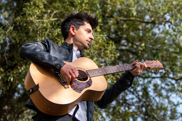 istock boy playing guitar outdoors in nature 1391738861
