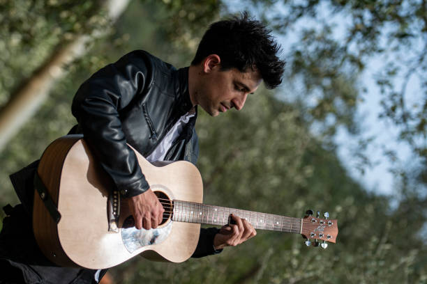 istock boy playing guitar outdoors in nature 1391738909