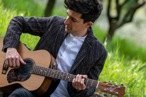 istock boy plays guitar surrounded by nature 1391739078