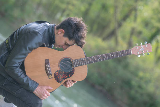 evocative photograph of boy with head resting on guitar