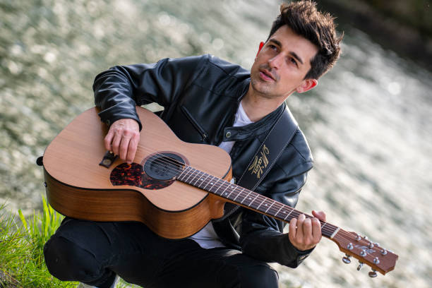 istock boy plays guitar by the river 1391739098
