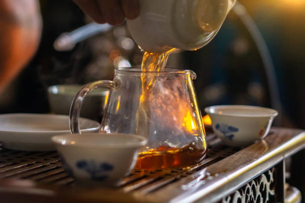 istock A hand that pours Chinese tea from a glass teapot into a small cup. Selective focus 1391740036