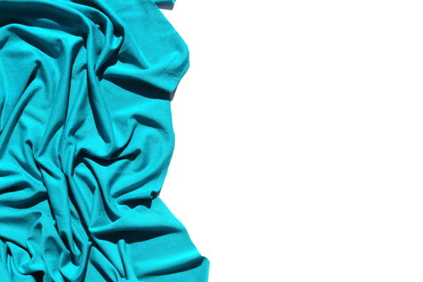 un tissu tricoté turquoise est plié en deux sous la forme d’une draperie sur fond blanc. - jersey en matière textile photos et images de collection