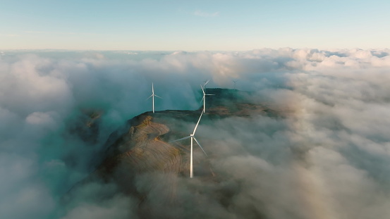 Wind turbines produce electricity in the mountains. Wind turbines hidden in the morning fog. Madeira, Portugal.