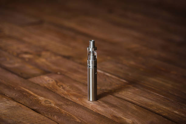 istock Electronic cigarette on a wooden table. Smoke 1391742802