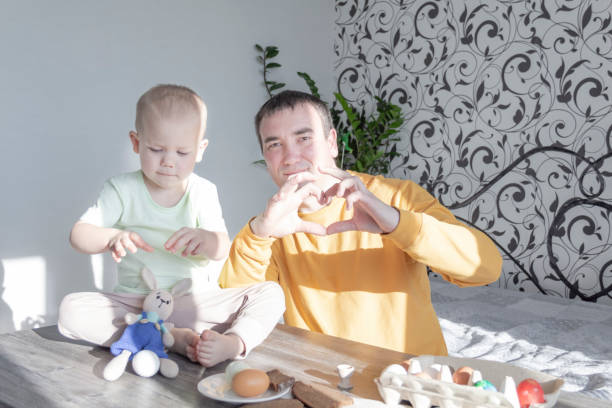 istock A dad celebrates Easter with his young son. They beat eggs, eat eggs and have breakfast. Dad teaches the child. 1391744267