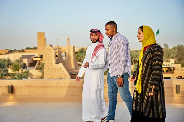 istock Saudi guide walking with couple visiting heritage site 1391746568