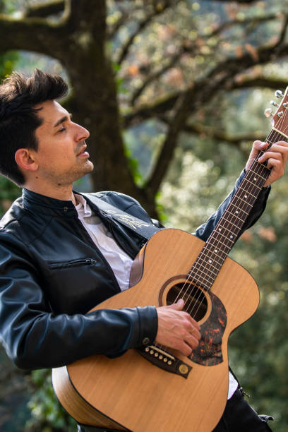 istock boy playing guitar outdoors in nature 1391746575